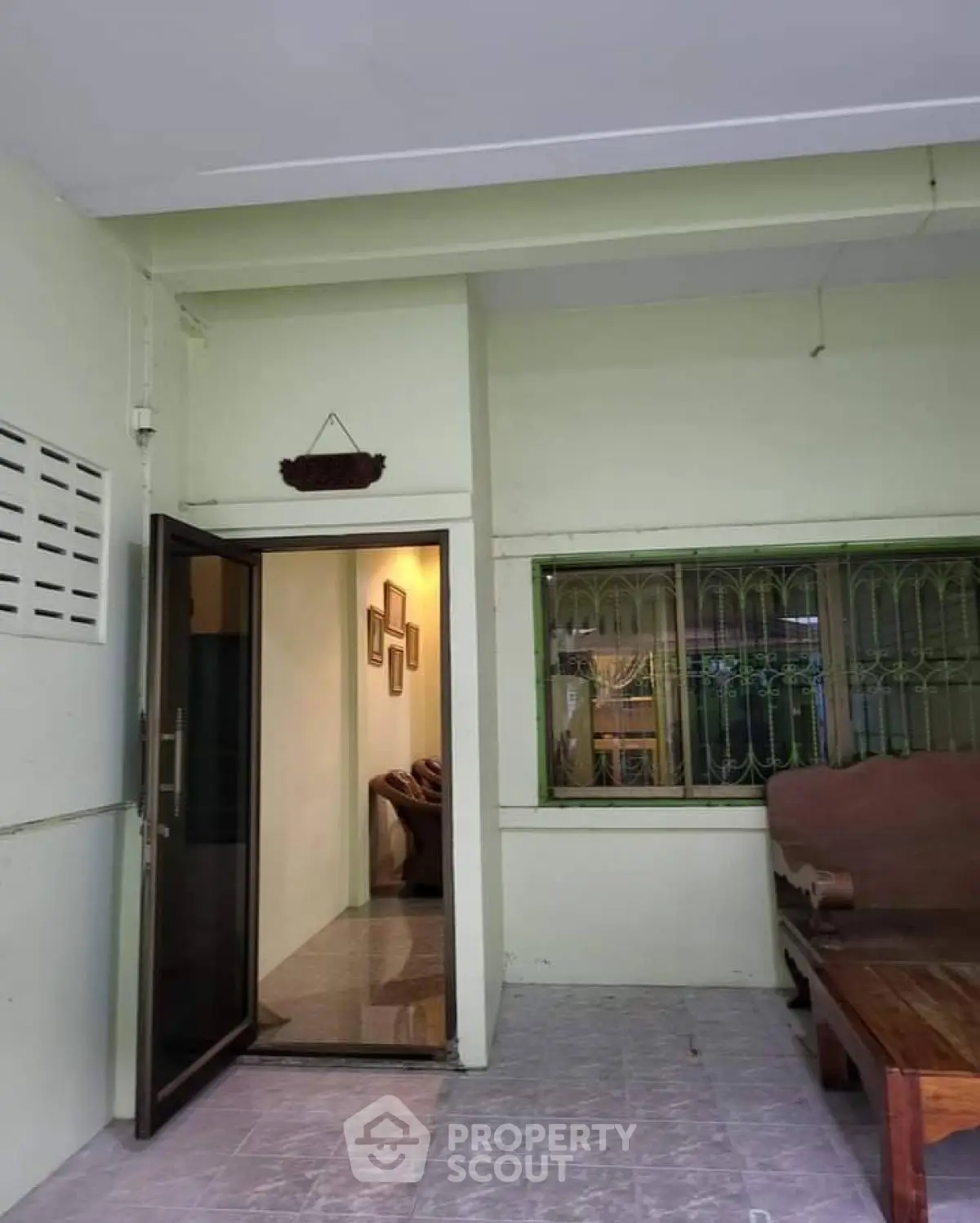 Charming entrance with cozy interior glimpse and inviting outdoor seating area.