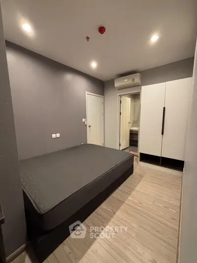 Modern bedroom with sleek design, featuring a comfortable bed, wardrobe, and air conditioning for ultimate comfort.