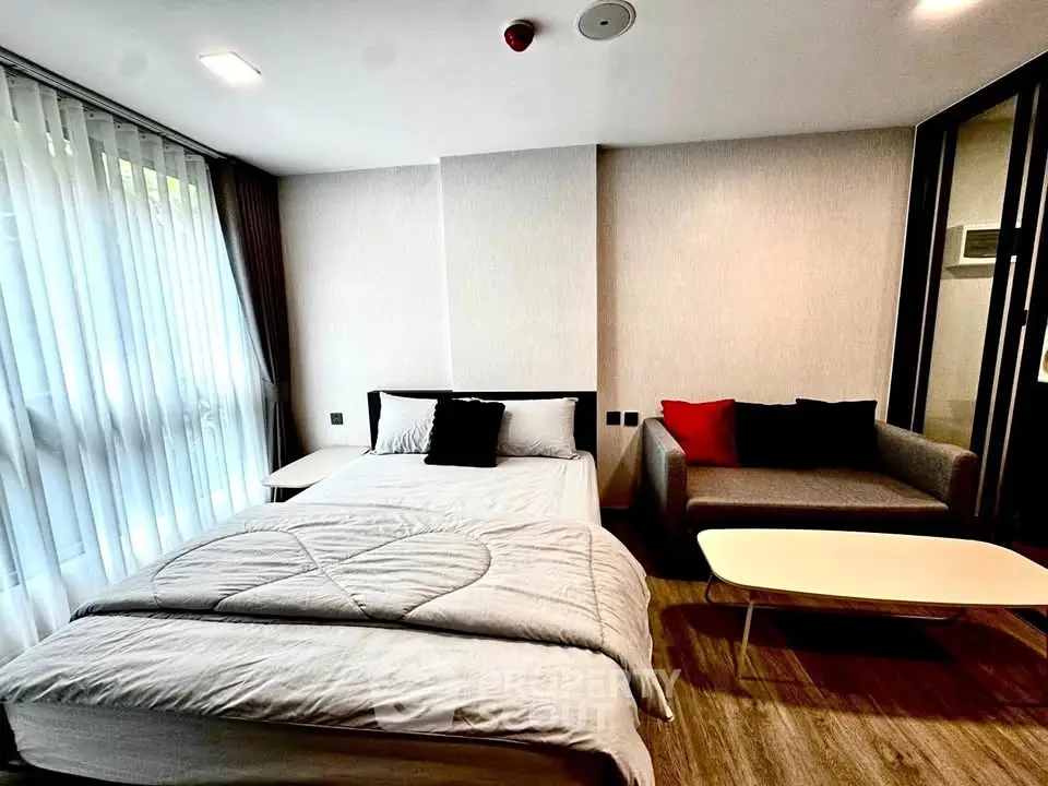 Modern bedroom with cozy bed and stylish sofa in a bright apartment