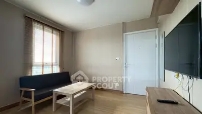 Modern living room with minimalist furniture and wall-mounted TV