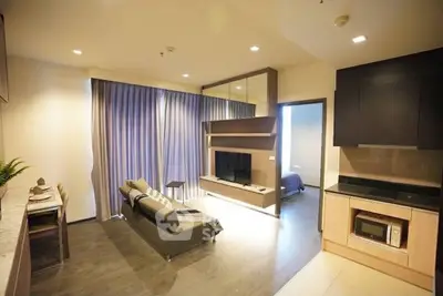 Modern open-plan living room with sleek kitchen and cozy furniture