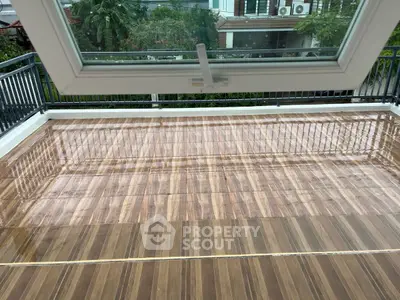 Spacious balcony with wooden flooring and modern railing, perfect for outdoor relaxation.