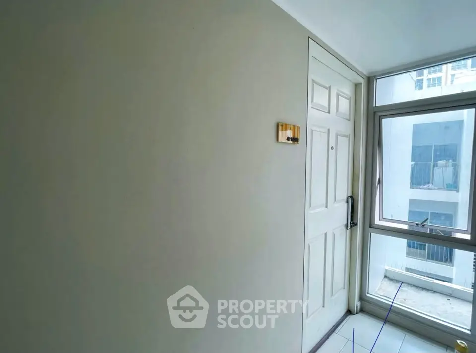 Modern apartment entrance with large window and white door