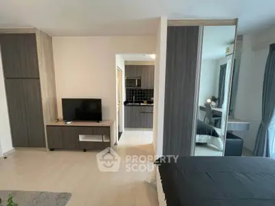 Modern studio apartment with sleek design, featuring a cozy living area and compact kitchen.
