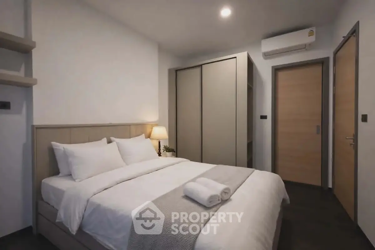 Modern bedroom with cozy bed, sleek wardrobe, and ambient lighting in a stylish apartment.