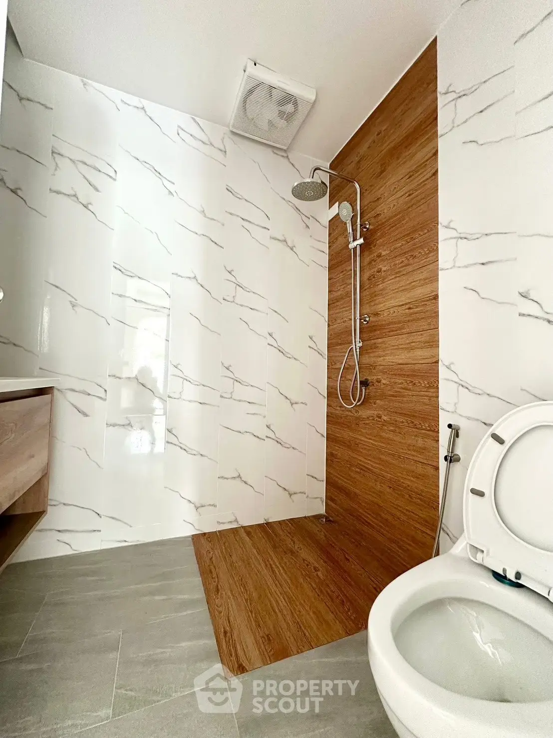 Modern bathroom with elegant marble and wood accents, featuring a sleek shower design.