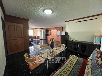 Spacious living room with modern decor and dining area, featuring stylish furniture and ample natural light.