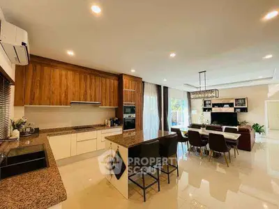 Spacious modern kitchen with island and dining area, featuring elegant wooden cabinetry and open layout.