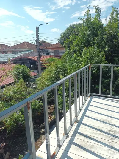Charming balcony with lush greenery and neighborhood view, perfect for relaxation and outdoor enjoyment.