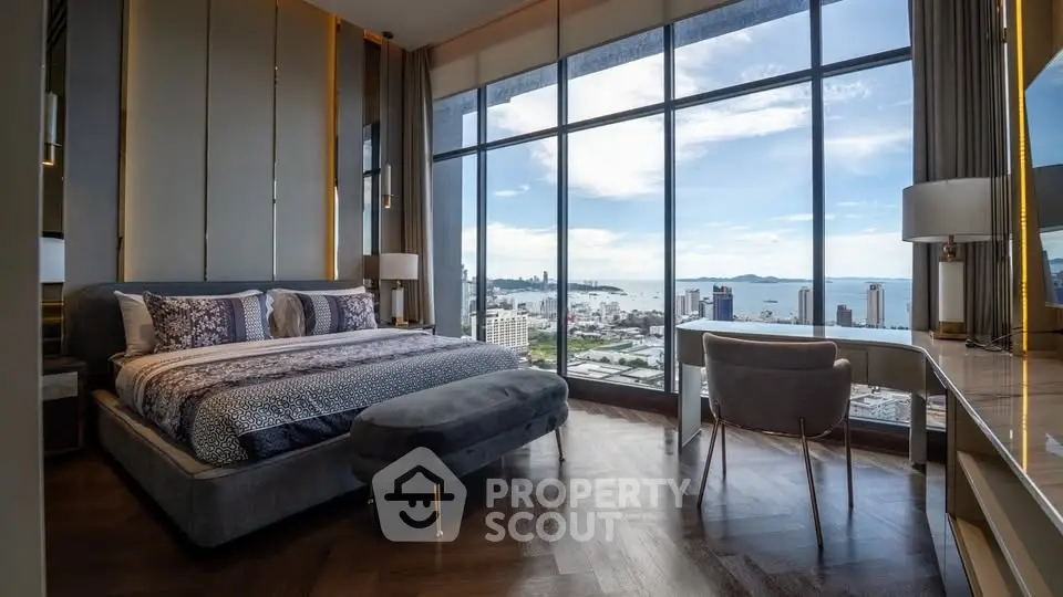 Luxurious bedroom with stunning city and ocean view from floor-to-ceiling windows.