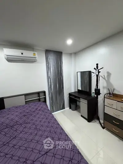 Cozy bedroom with modern furniture and air conditioning, perfect for relaxation.