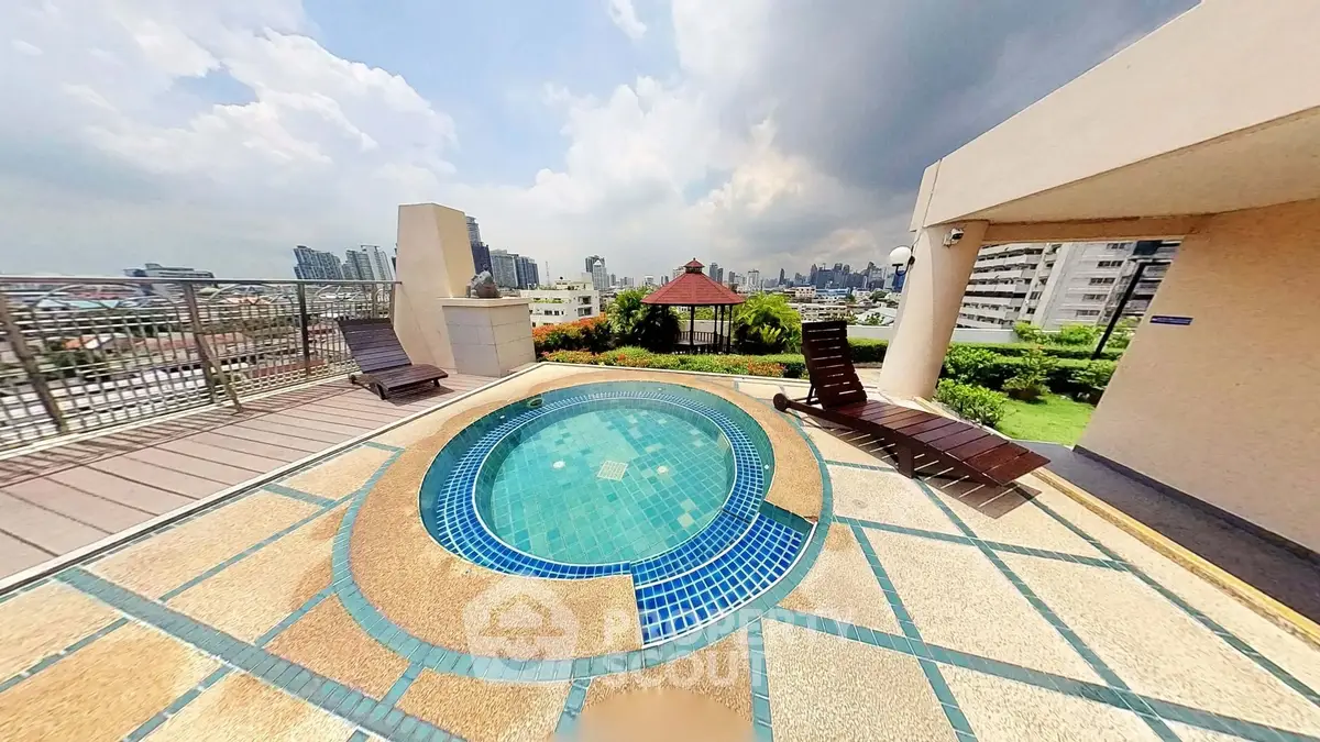 Luxurious rooftop jacuzzi with stunning city skyline views and relaxing lounge chairs.