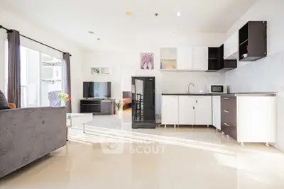 Modern open-plan living room with sleek kitchen and natural light