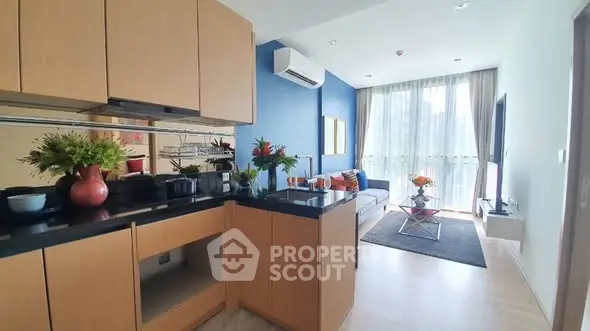 Modern open-layout kitchen and living room with stylish decor and natural light.