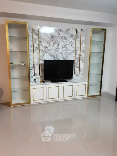 Elegant living room with marble TV wall and glass cabinets