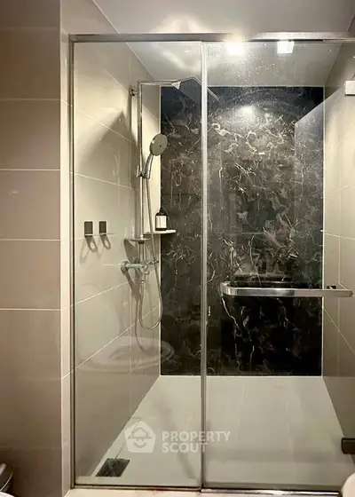 Modern bathroom with sleek glass shower enclosure and elegant tile design.