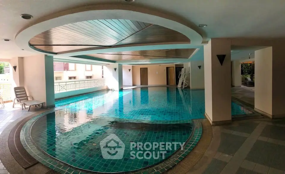 Luxurious indoor swimming pool with modern design and natural lighting in upscale residential building.