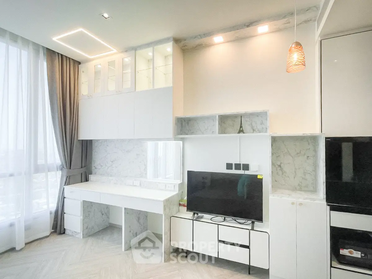 Modern living room with sleek white cabinetry and marble accents