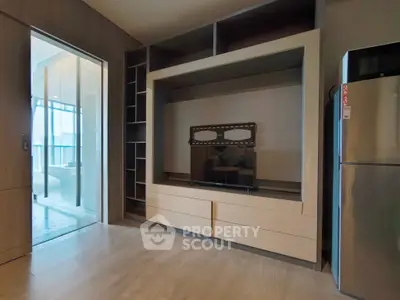 Modern living room with built-in entertainment center and sleek refrigerator