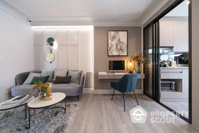 Modern living room with elegant decor, sleek furniture, and an open layout leading to a well-equipped kitchen, perfect for entertaining.