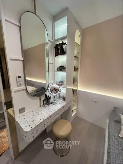 Modern bedroom with stylish vanity area and built-in storage, featuring elegant lighting and contemporary design.