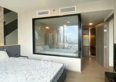 Modern bedroom with glass-walled bathroom and city view