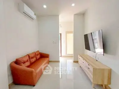 Modern living room with sleek design, featuring a comfortable sofa and wall-mounted TV.