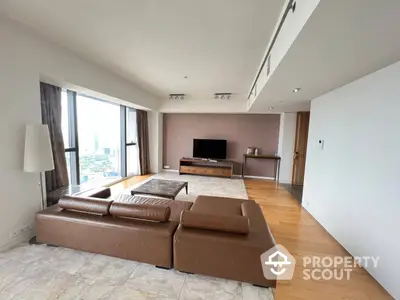 Spacious living room with large windows offering abundant natural light, modern furniture, and a serene city view, perfect for relaxation and entertaining guests.