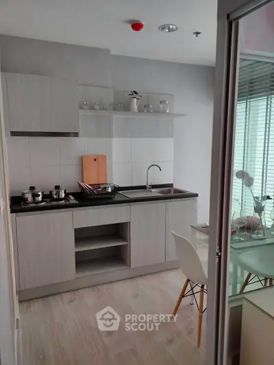 Modern kitchen with sleek cabinetry and dining area in a stylish apartment