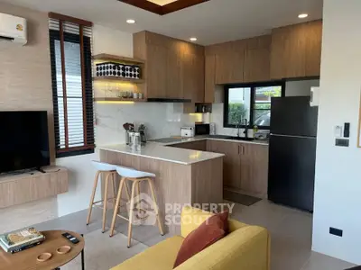 Modern open-layout kitchen and living room with stylish decor and appliances.