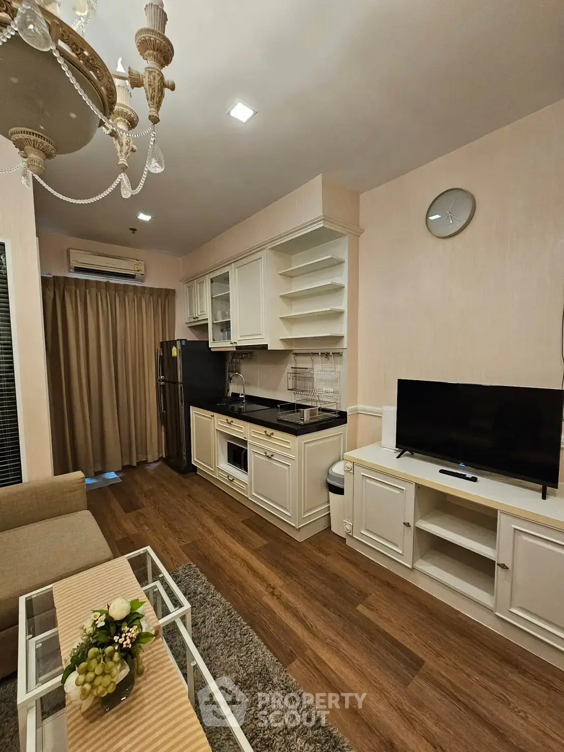 Charming living room with elegant kitchen, featuring hardwood floors and stylish decor, perfect for modern living.