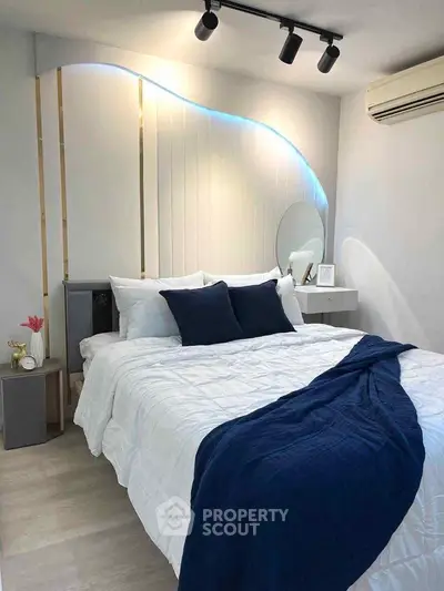 Modern bedroom with stylish lighting and cozy bedding in a contemporary apartment.