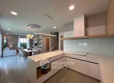 Modern open-plan kitchen and living area with sleek design and ample natural light.
