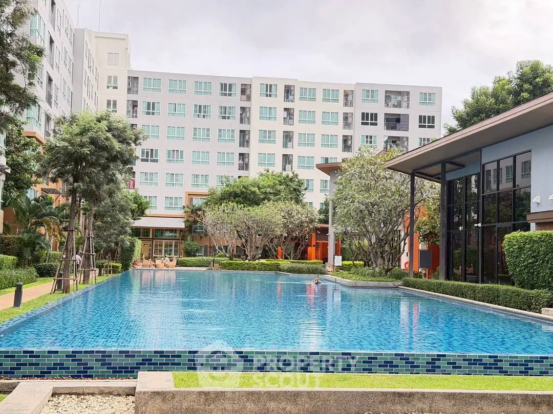 Modern apartment complex with a large swimming pool and lush greenery, perfect for luxury living.