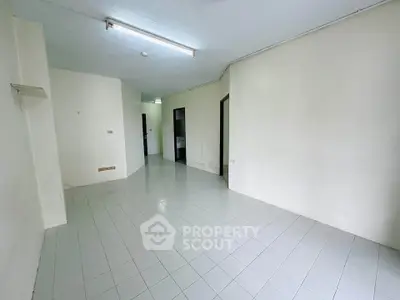 Spacious empty room with tiled flooring and white walls, ideal for customization.