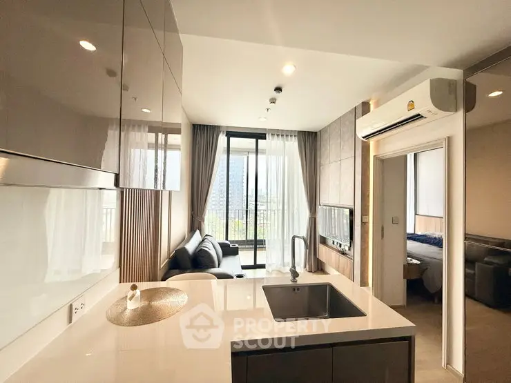 Modern open-layout kitchen and living area with balcony view in stylish apartment