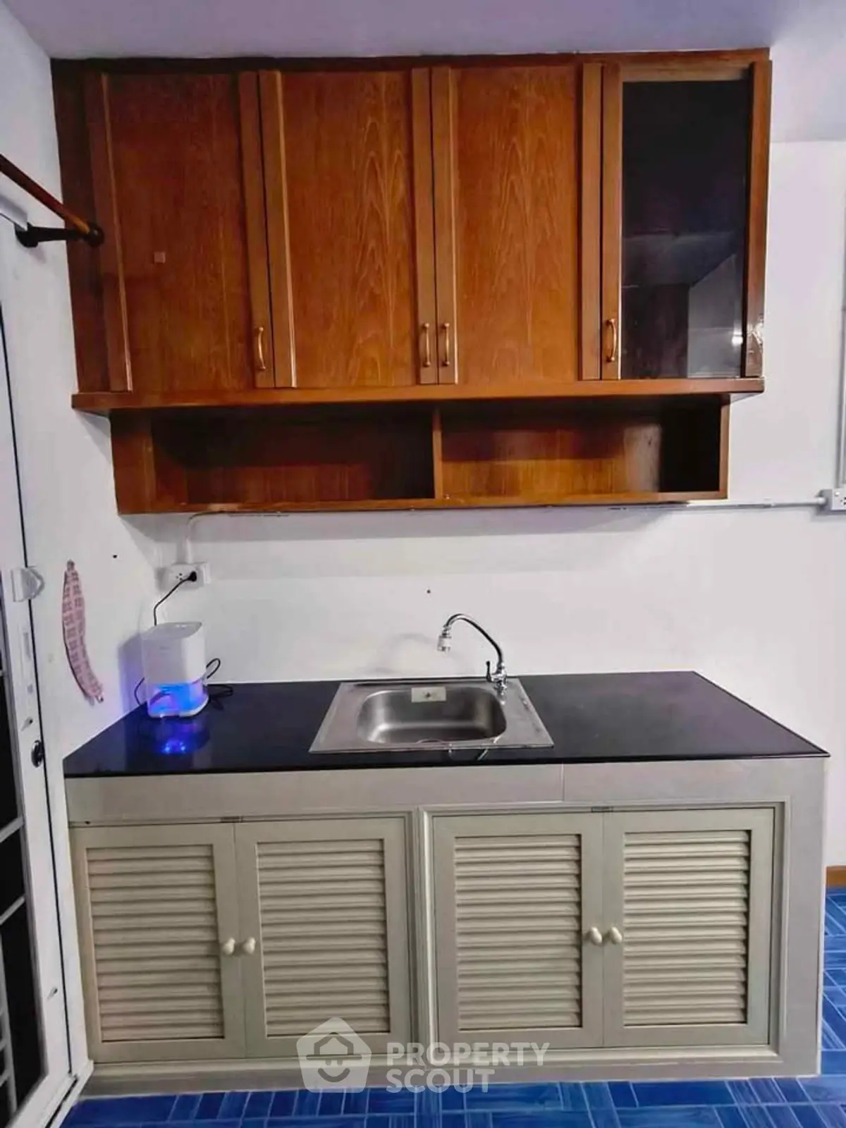Charming kitchen with wooden cabinets and sleek countertop, perfect for modern living.