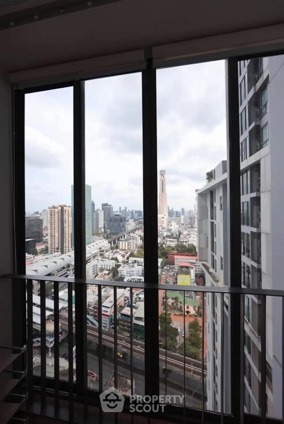 Stunning cityscape view from high-rise apartment window, showcasing urban skyline and modern architecture.