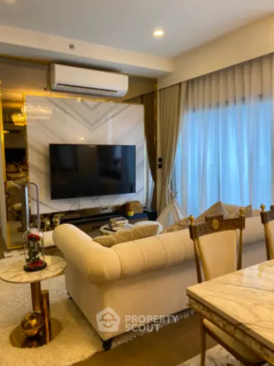 Luxurious living room with elegant decor and modern amenities, featuring a plush sofa and large TV.