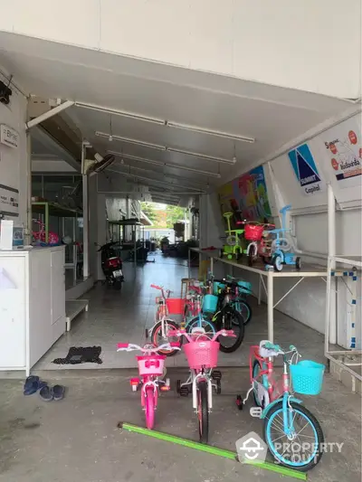 Spacious commercial space with bicycles, ideal for retail or showroom use, featuring ample natural light.