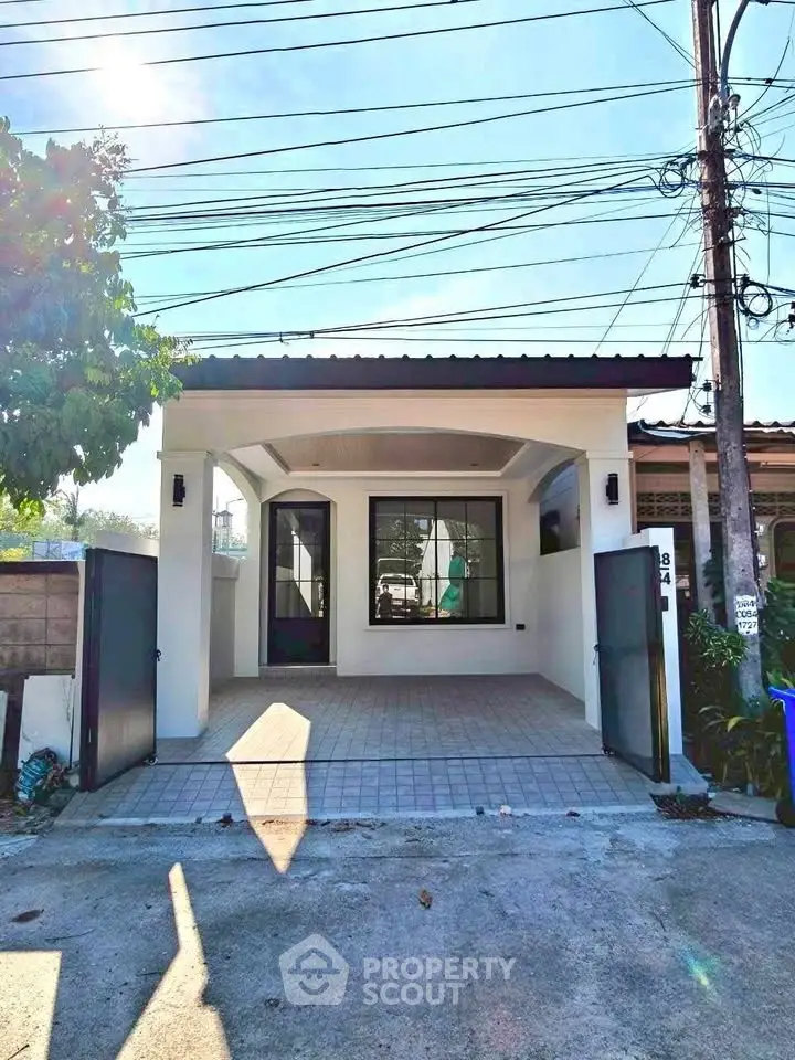 Charming single-story home with gated driveway and modern facade, perfect for cozy living.