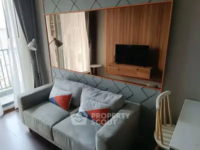 Modern living room with stylish sofa, large mirror, and balcony view in urban apartment.