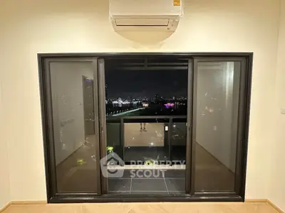 Stunning night view from modern apartment balcony with sleek sliding glass doors and air conditioning unit.