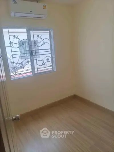 Cozy small room with wooden flooring and window view, perfect for a compact living space.