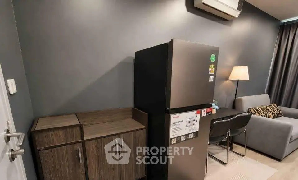 Modern apartment interior with sleek fridge, stylish furniture, and ambient lighting.