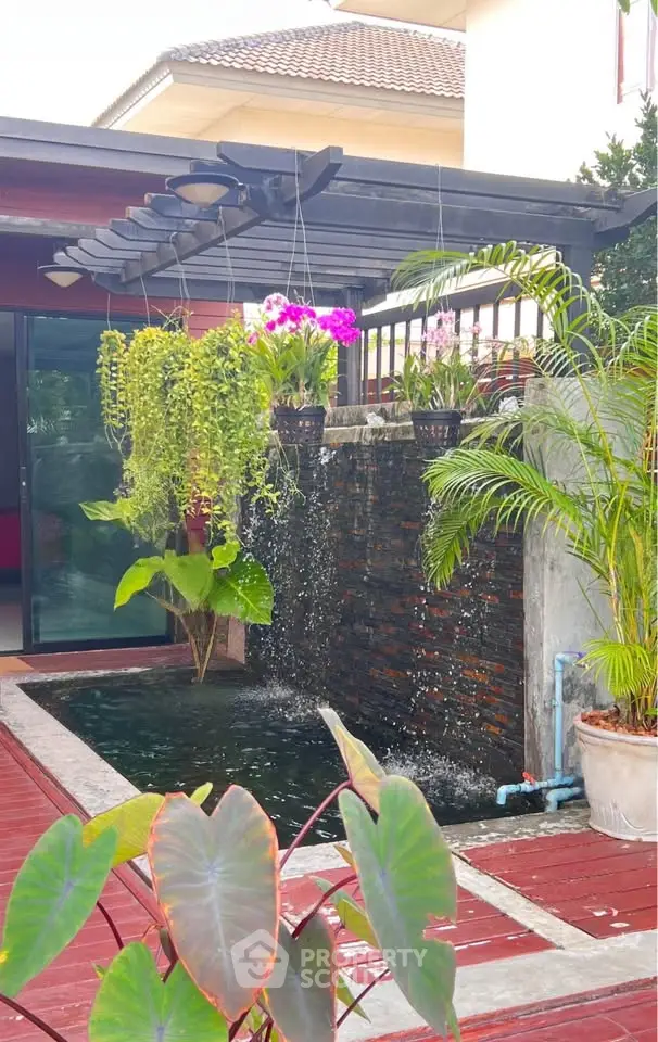 Charming garden with a cascading water feature and lush greenery in a modern home setting.