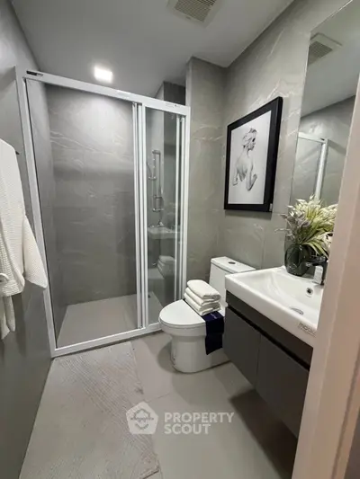 Modern bathroom with sleek shower and elegant decor in a stylish apartment.