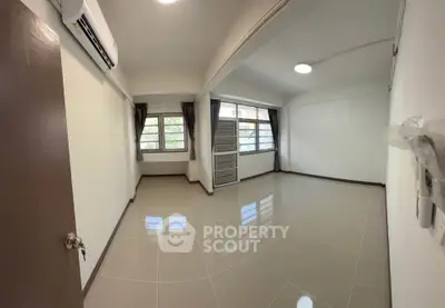 Spacious unfurnished room with large windows and air conditioning, perfect for customization.