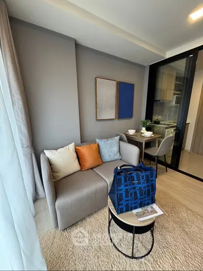 Modern living room with cozy sofa and open kitchen layout in stylish apartment.