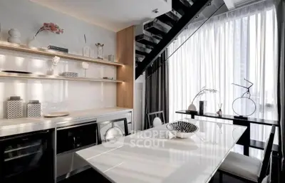 Modern dining area with sleek design and natural light under a stylish staircase.